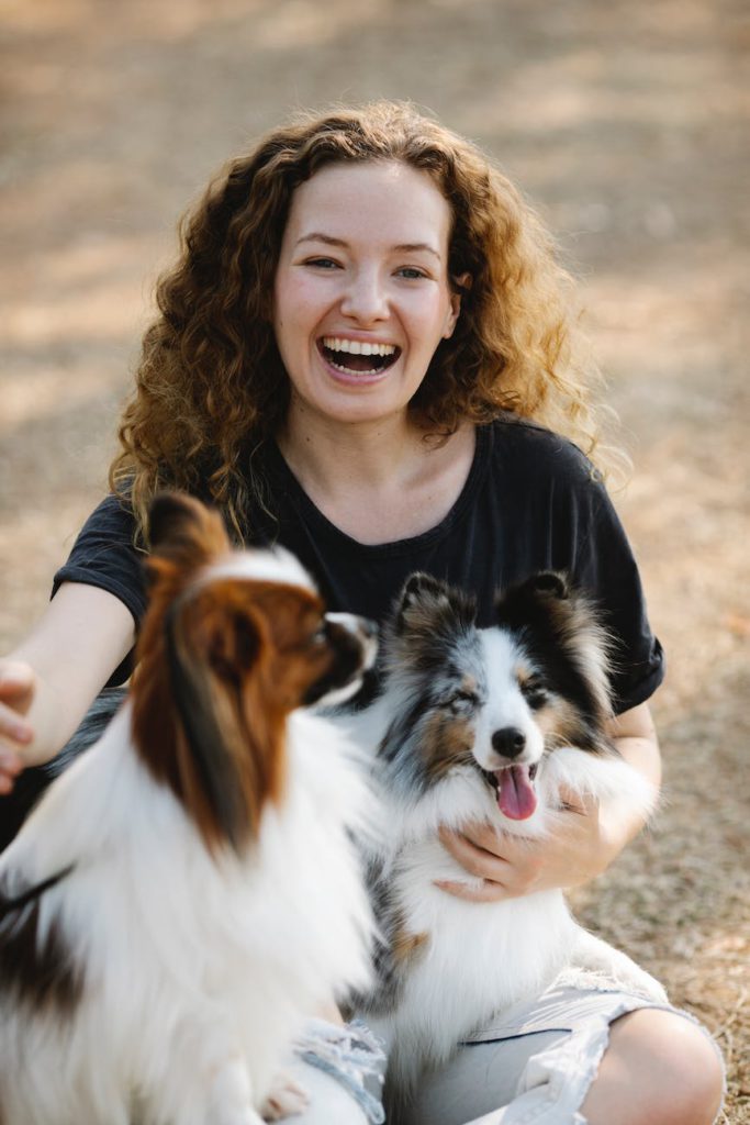 a happy woman posing with two dogs