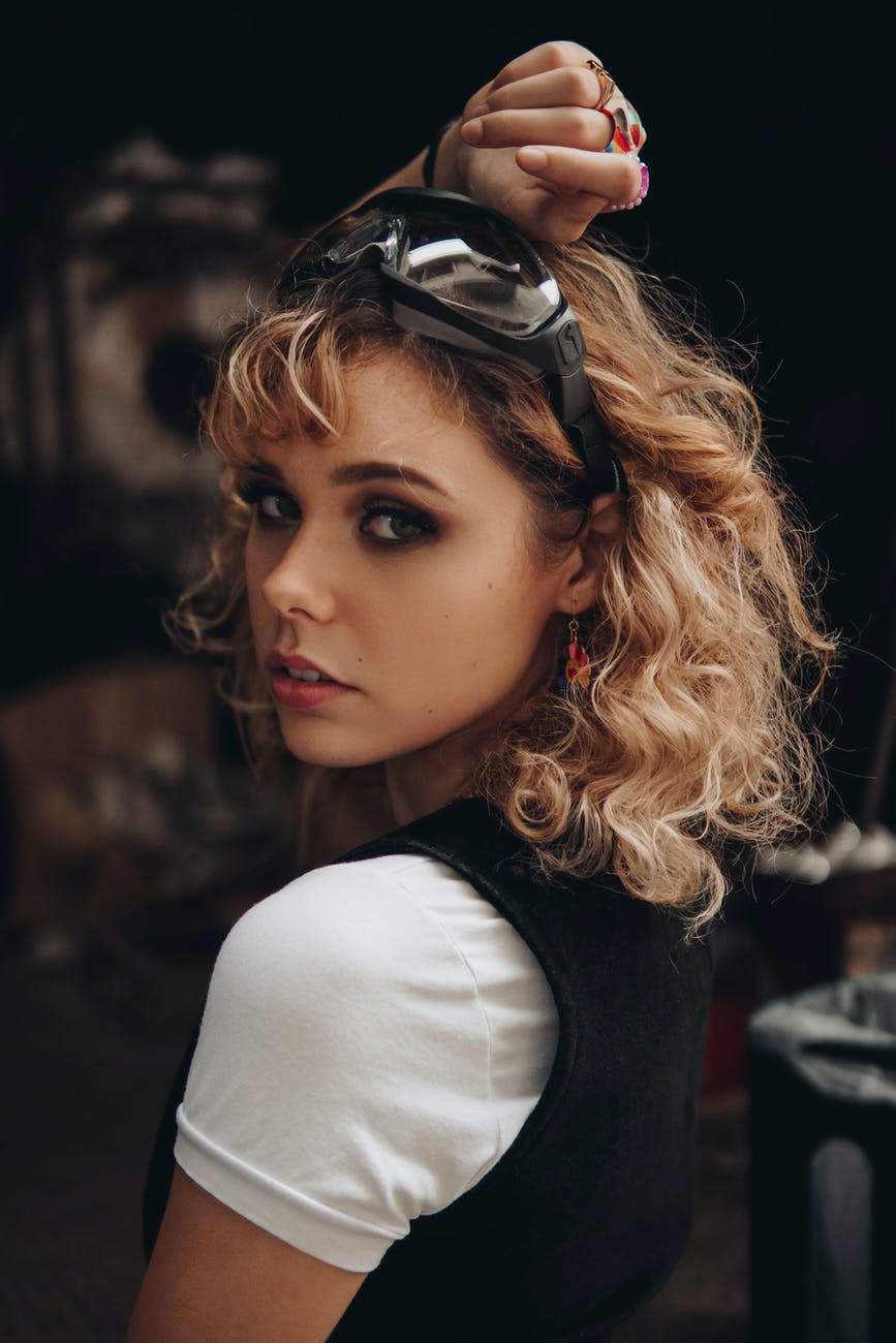 attractive woman with blond wavy hair looking over shoulder