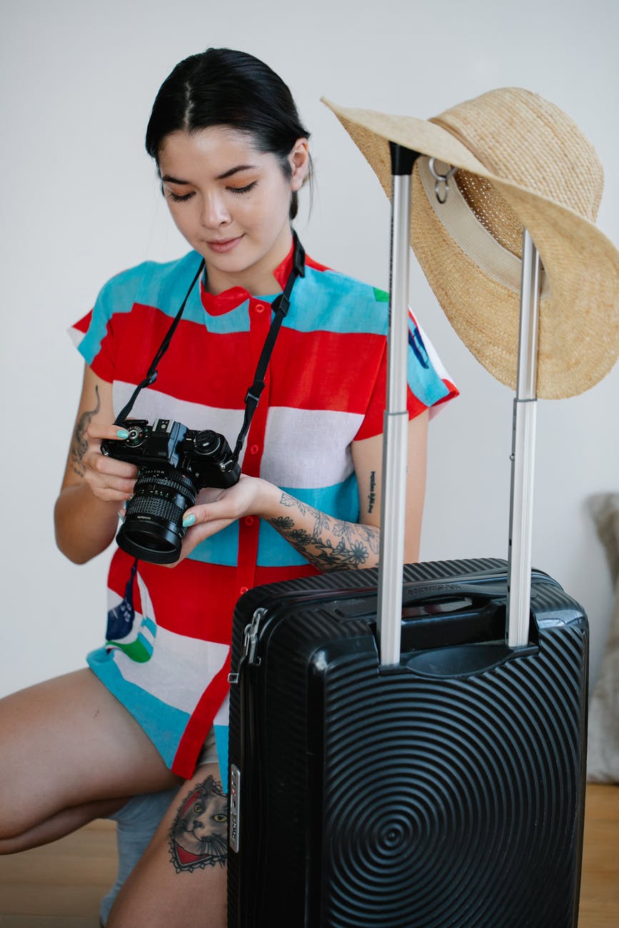 a woman holding her camera near her luggage
