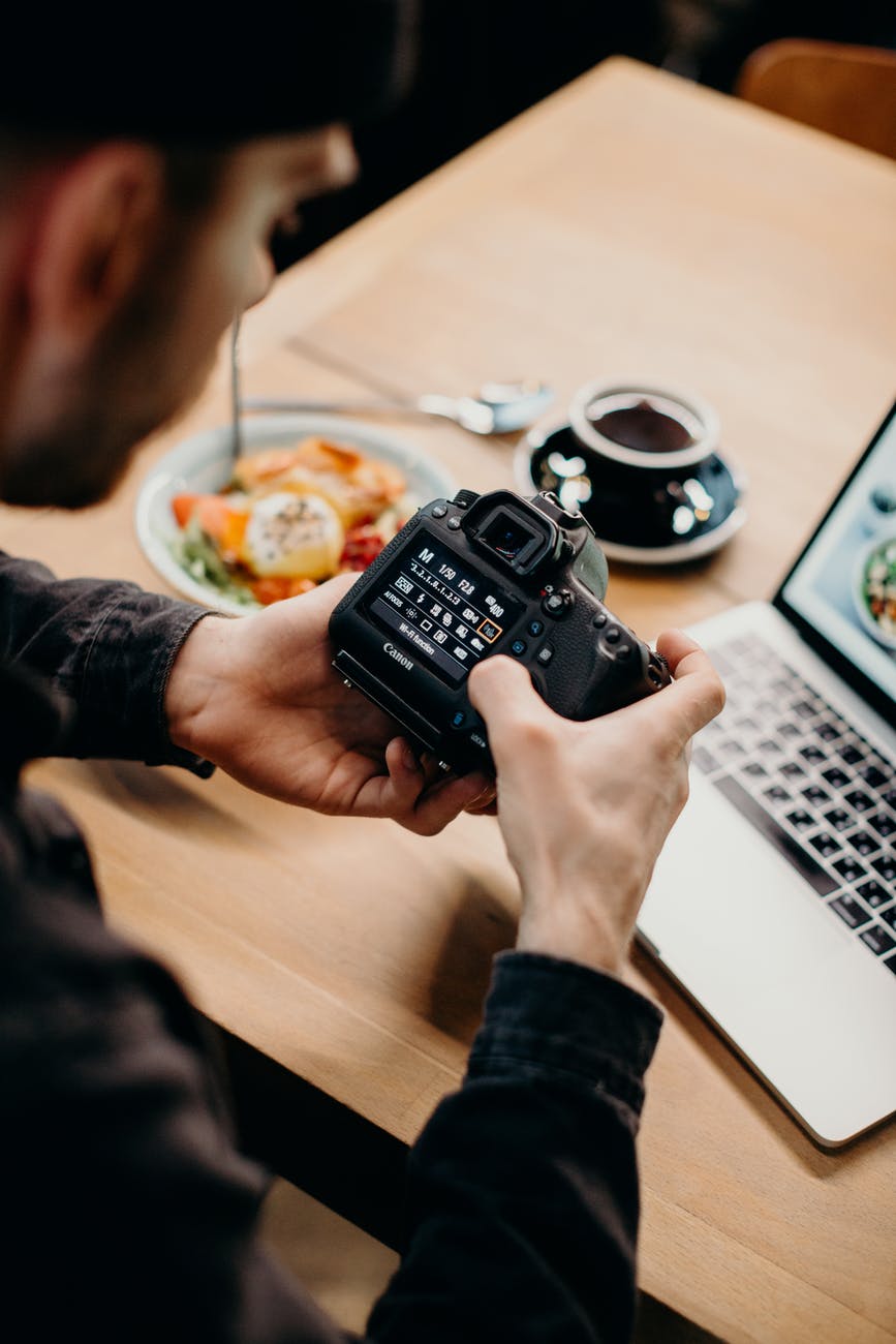 selective focus photography of man using black dslr camera