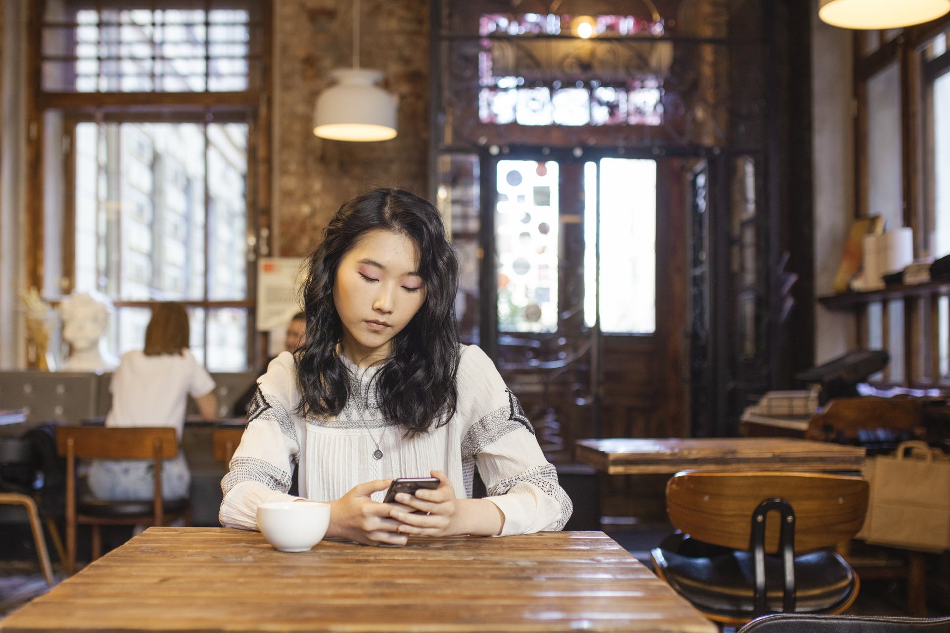 woman sitting on the table holding her cellphone
