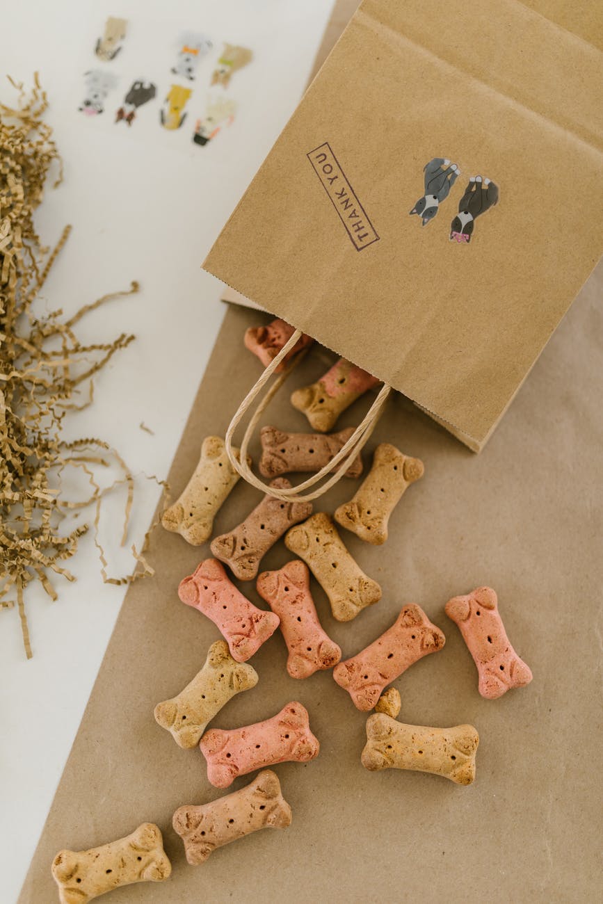 a paper bag with dog treats on a brown table
