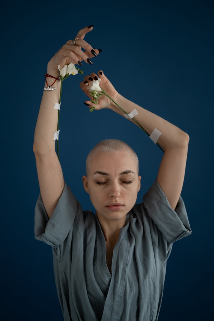 mindful woman with blooming flowers and raised arms
