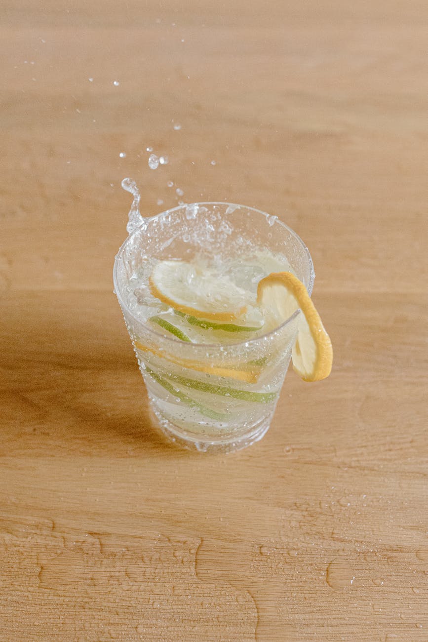 glass with refreshing drink decorated with lemon and lime slices