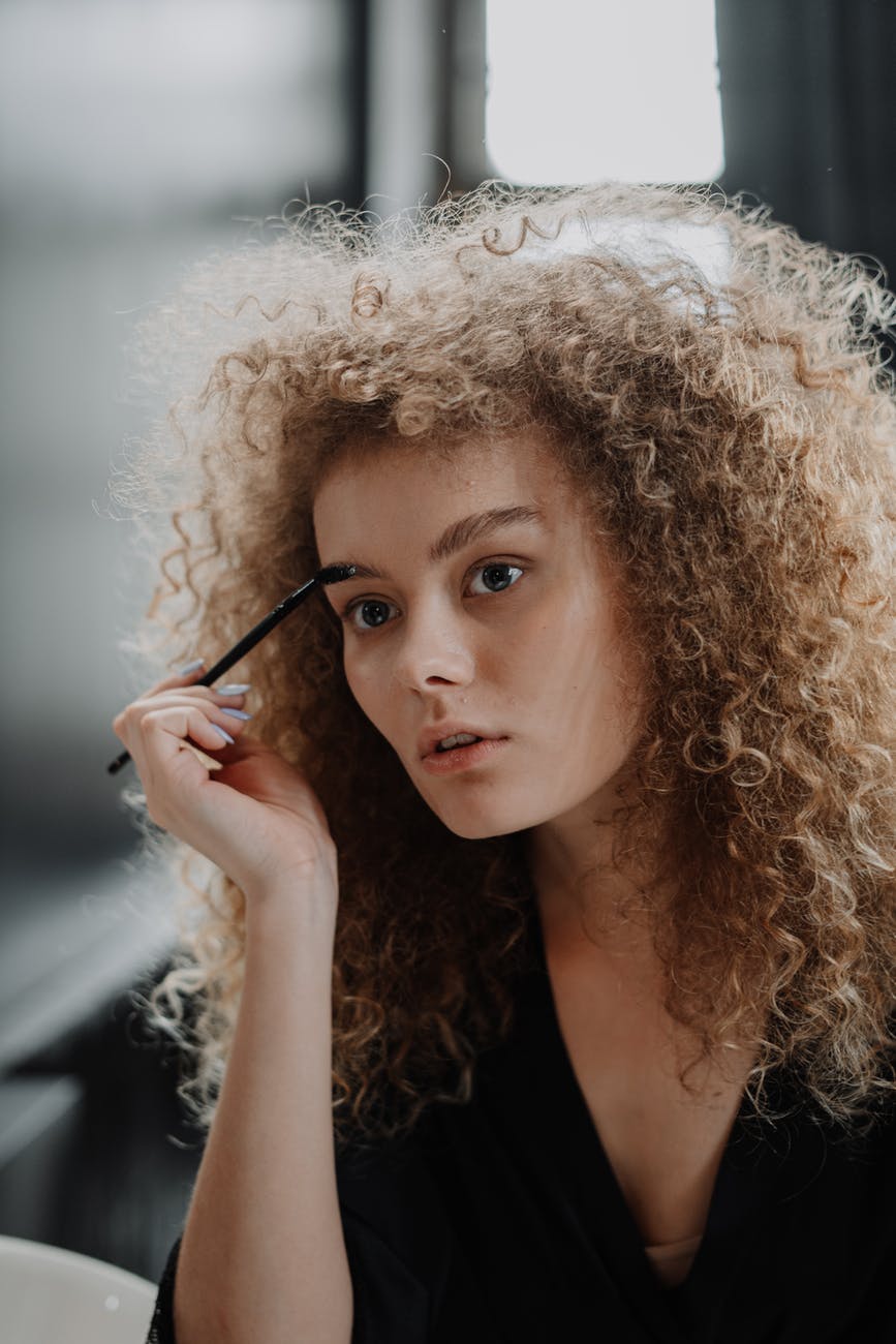 woman in white fur coat holding black pen