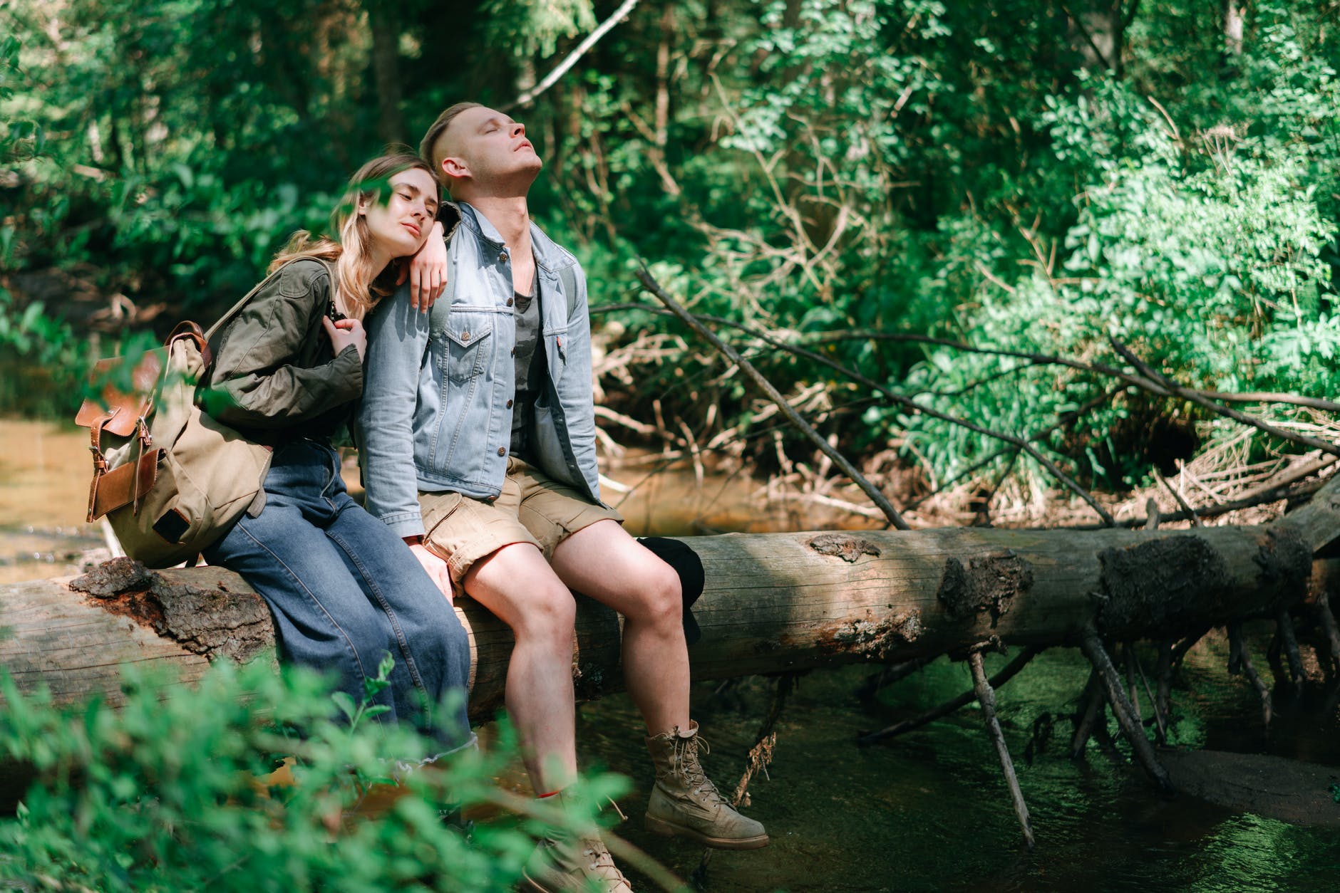 a man and a woman sitting on a wooden log