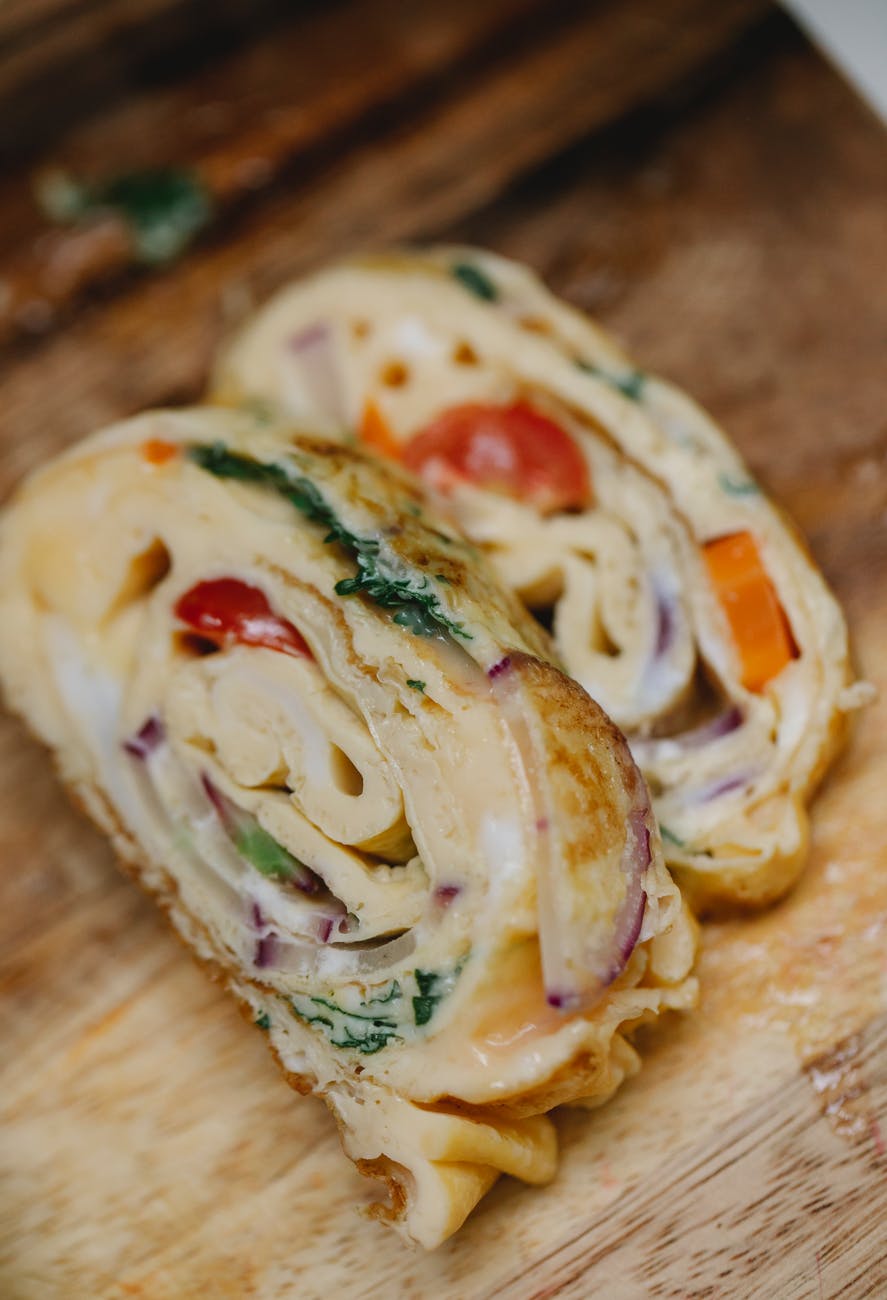 appetizing egg rolls with ripe vegetables on cutting board