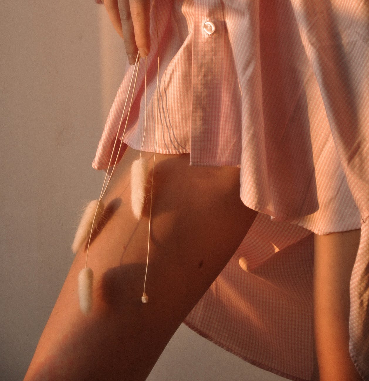 delicate woman caressing leg with soft twig