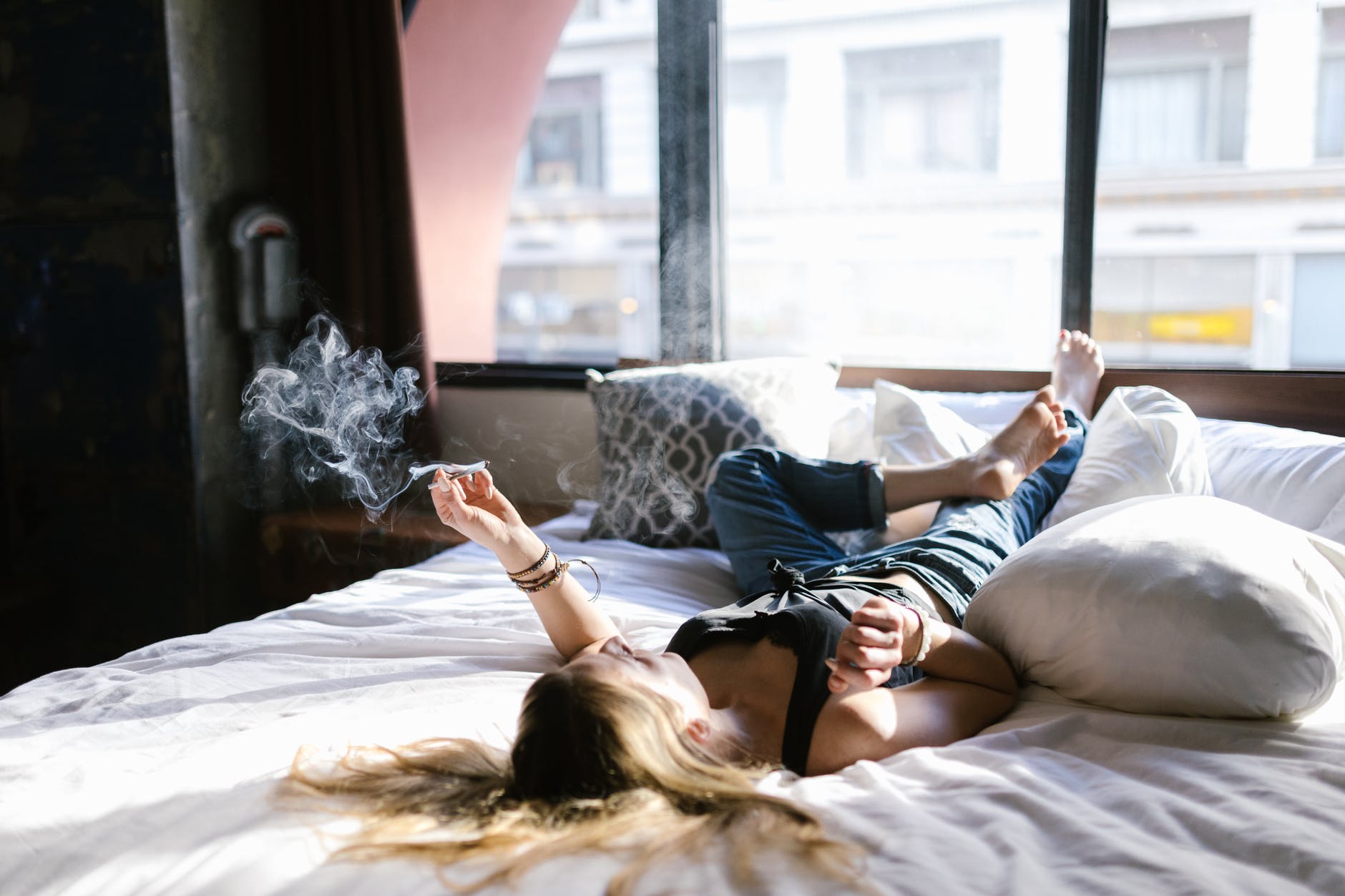 woman in black tank top lying on bed