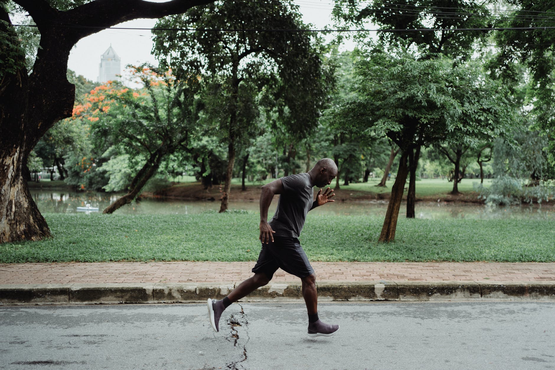 man in gray t shirt and black shorts running