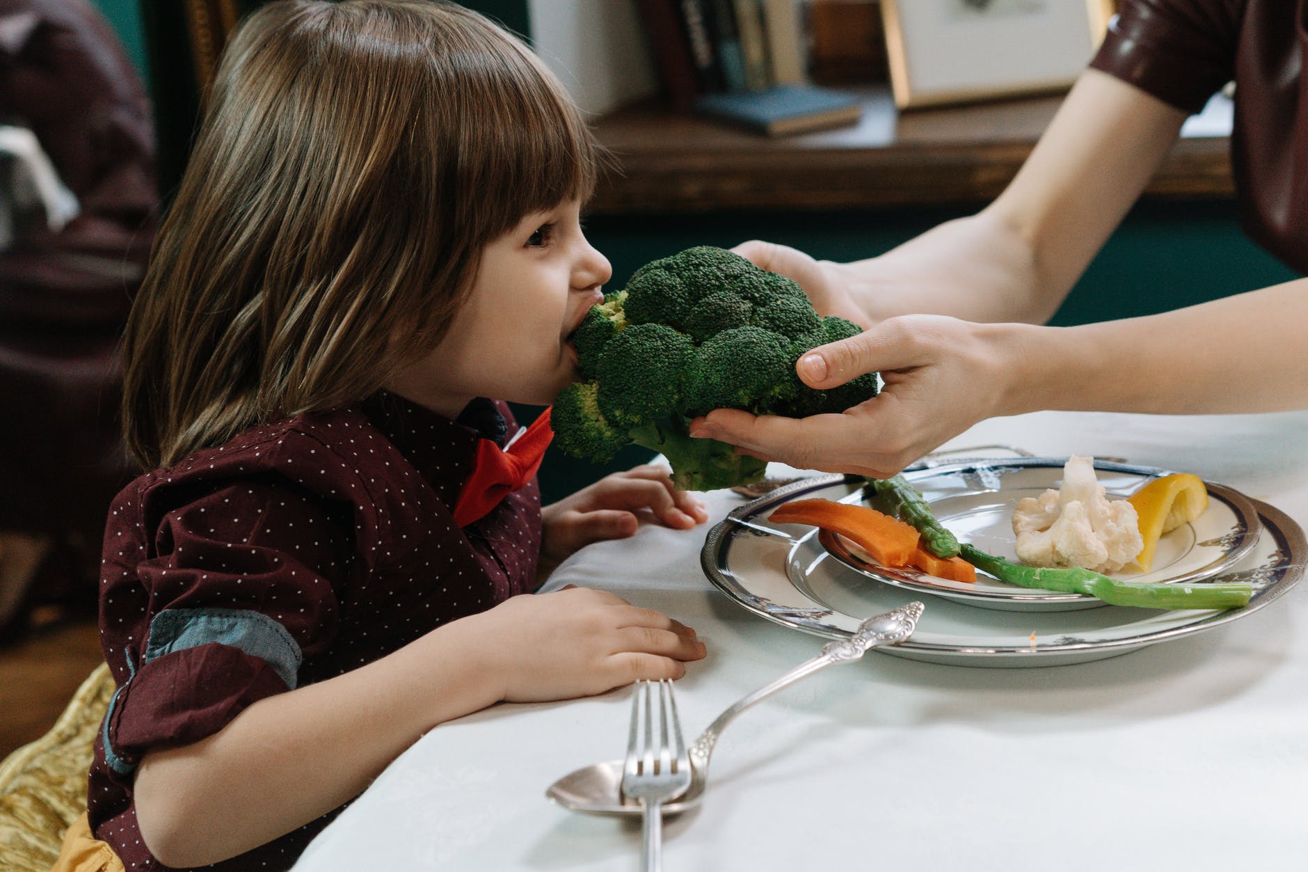 boy biting on a broccoli