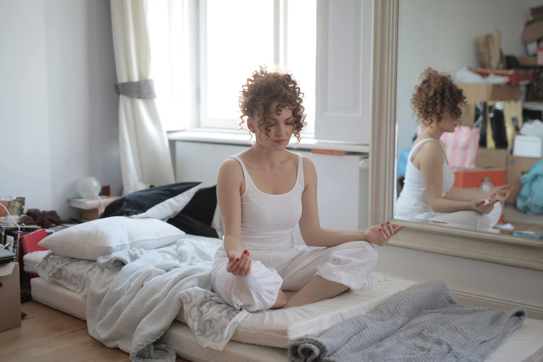 calm woman in lotus pose meditating after awakening at home