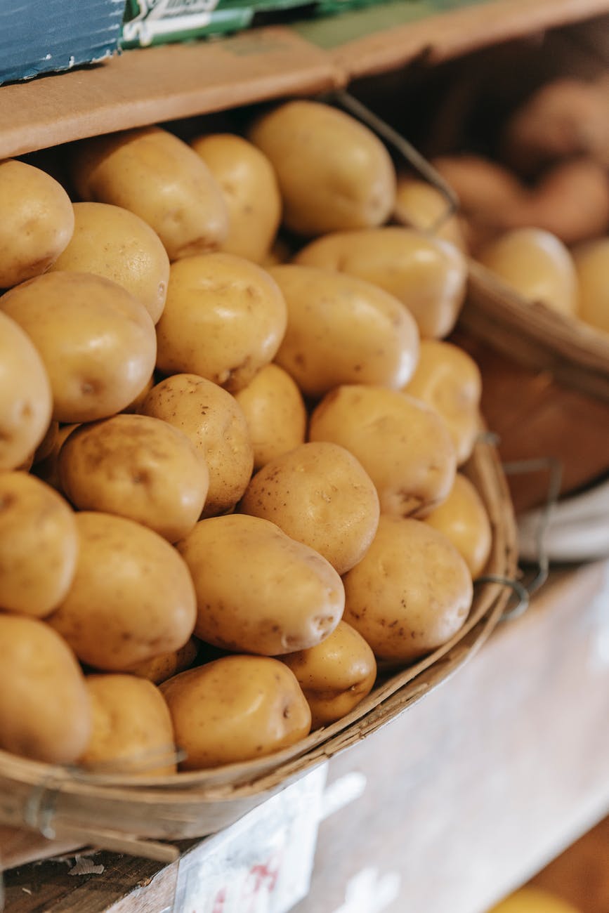 basket with fresh potatoes placed on counter in market