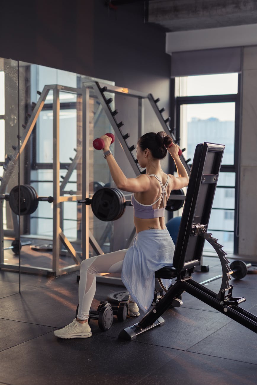 photo of woman raising dumbbells