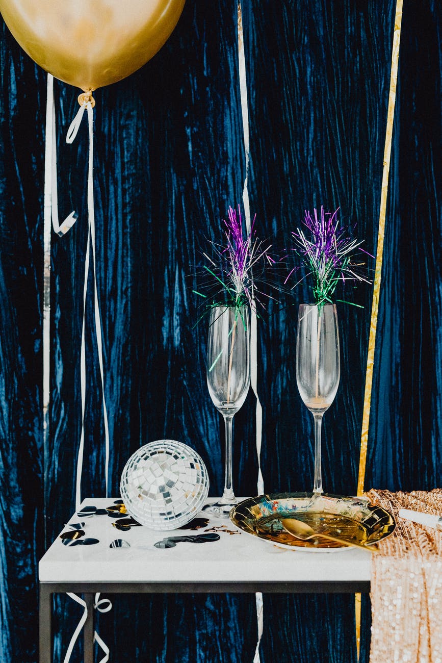 purple flowers on white and blue floral ceramic plate beside clear glass bowl