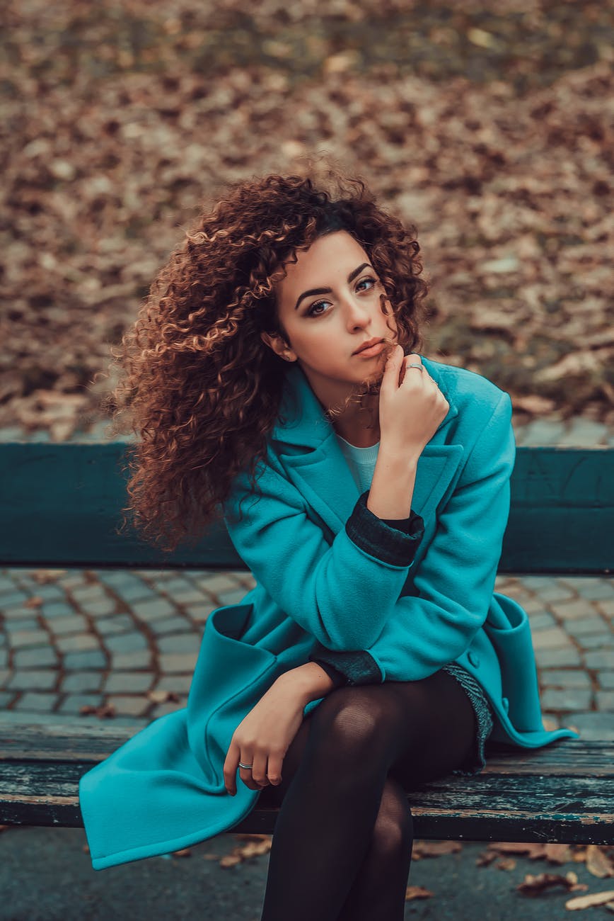 photo of woman sitting on park bench
