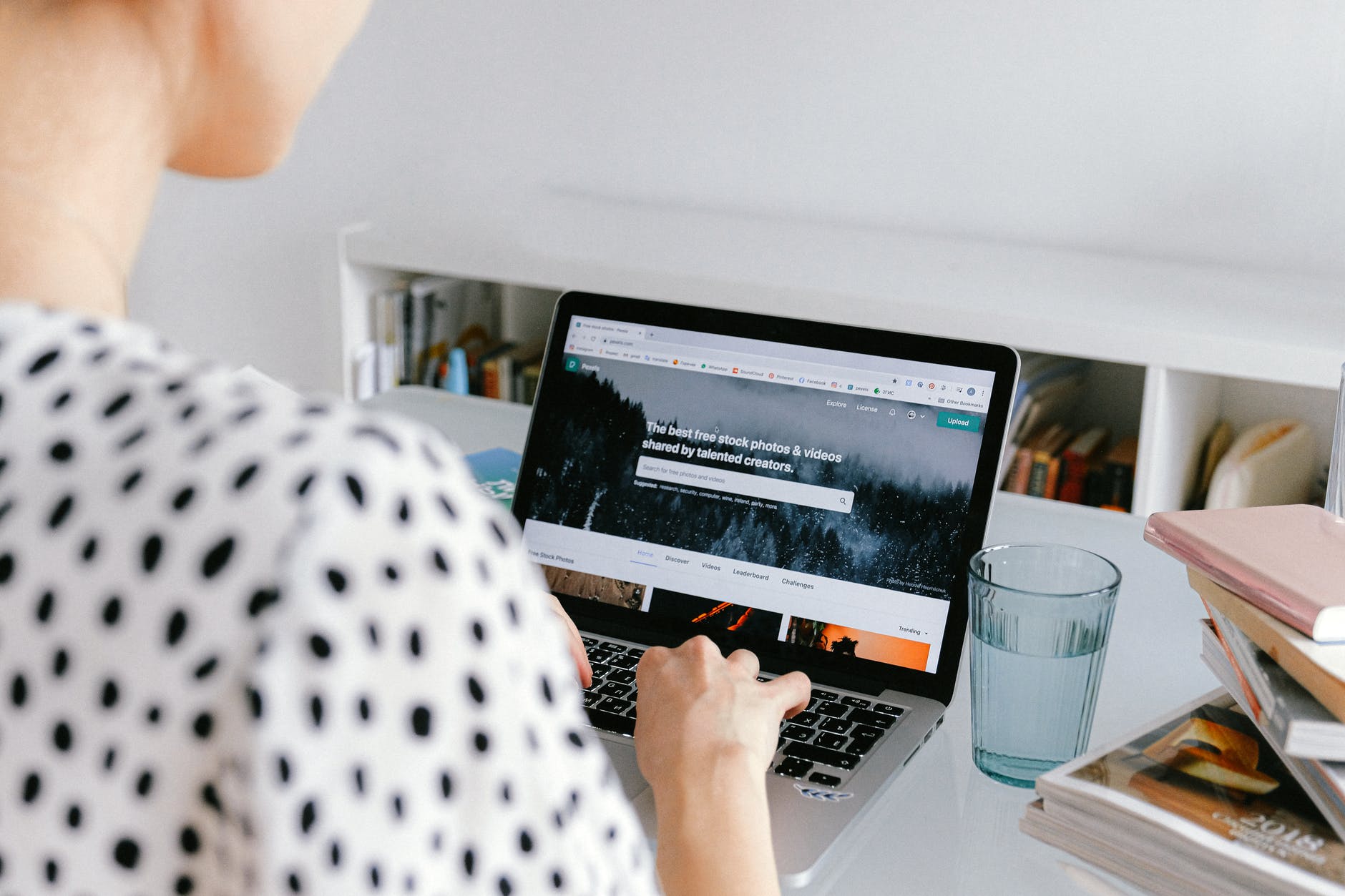 person using macbook on white table