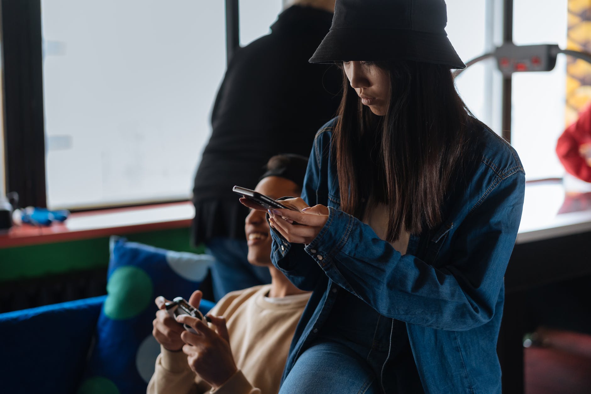 woman wearing black bucket hat using her smartphone