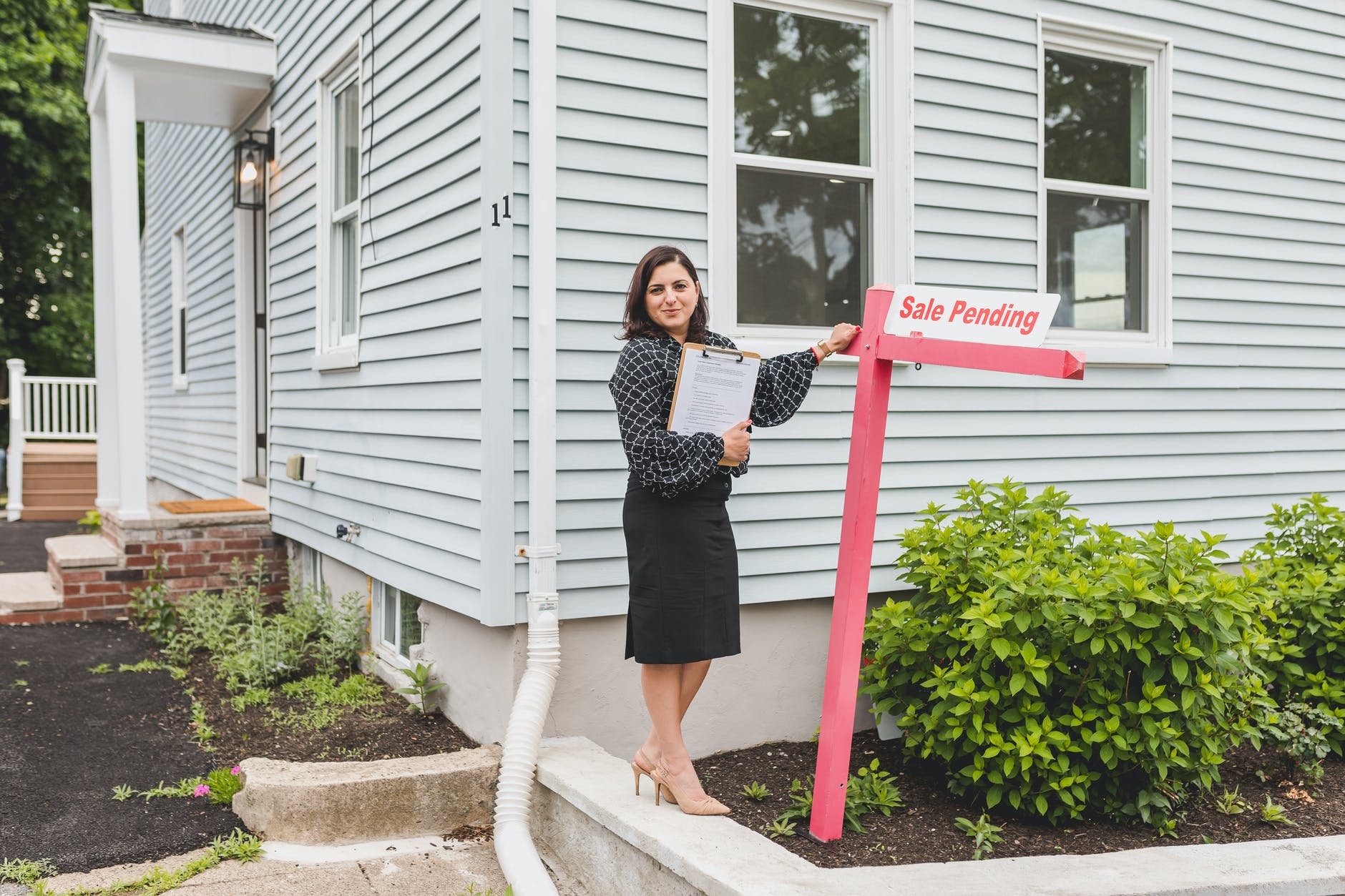 a broker standing besides a sign