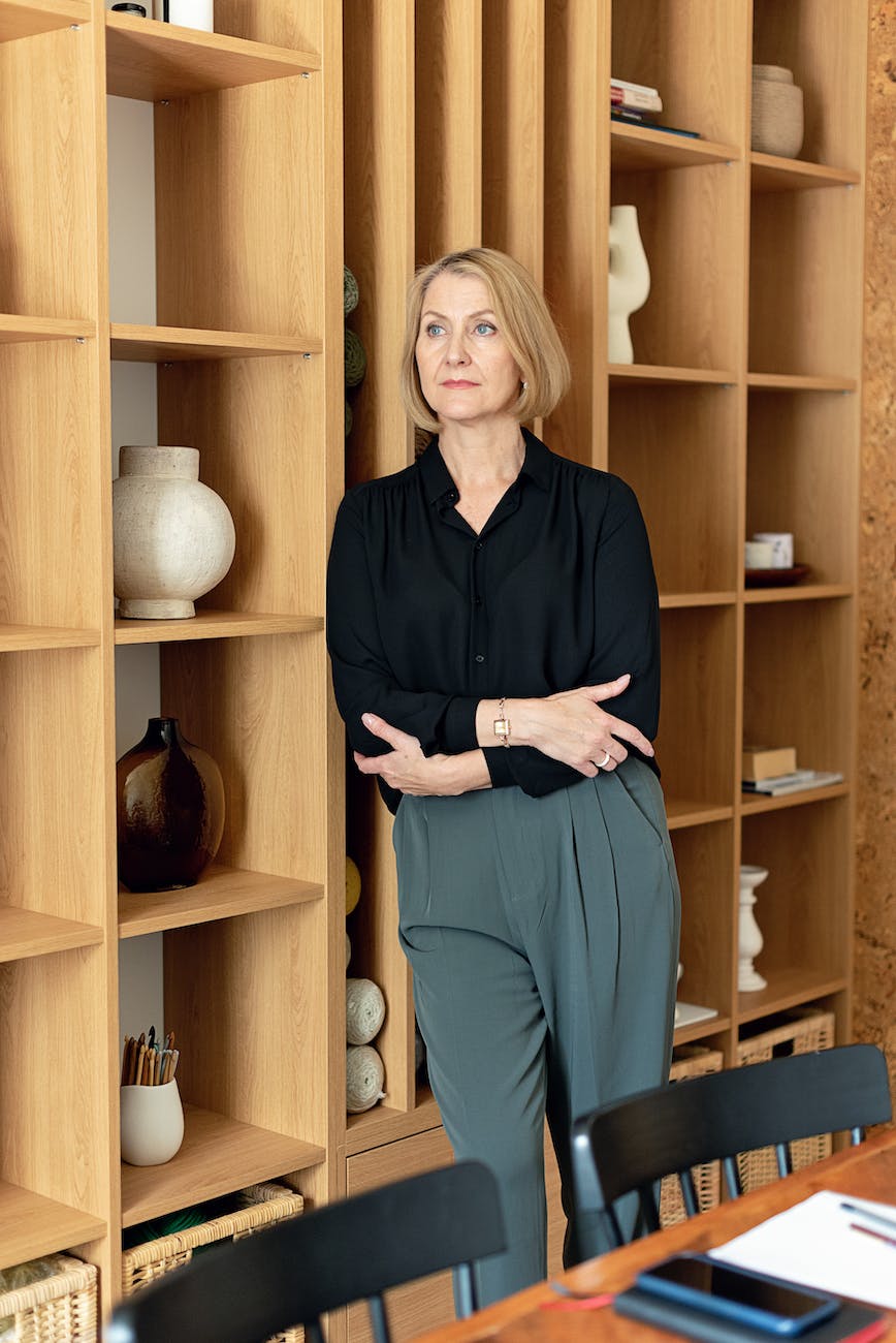 a businesswoman leaning on a shelf