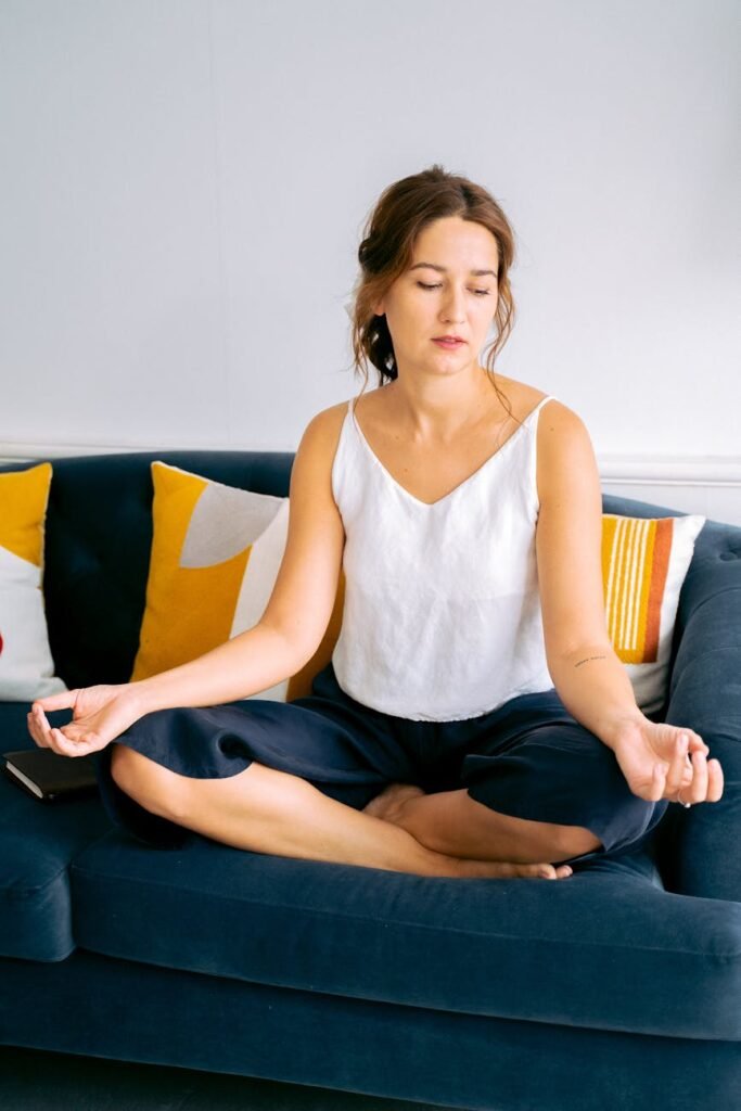 woman in white top sitting on blue couch