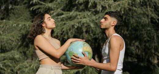 a man and a woman with eyes closed holding a globe